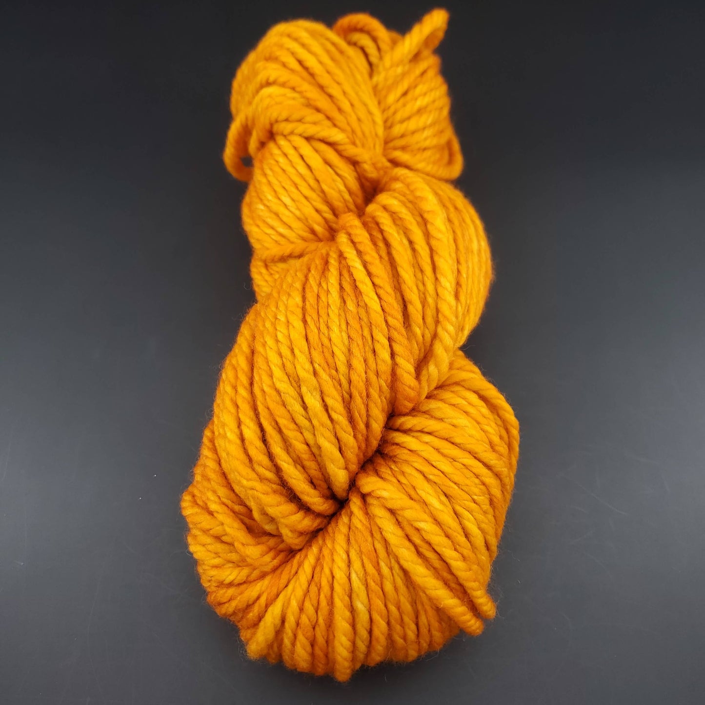 Echeveau de laine Malabrigo Chunky de couleur 096 sunset sur fond noir pour tricot et crochet.