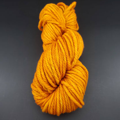 Echeveau de laine Malabrigo Chunky de couleur 096 sunset sur fond noir pour tricot et crochet.