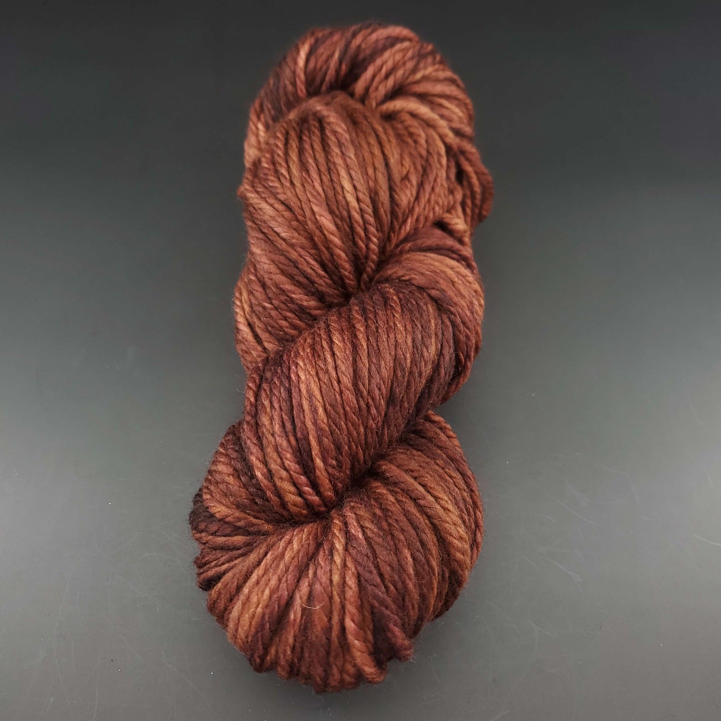 Echeveau de laine Malabrigo Chunky de couleur 161 rich chocolate sur fond noir pour tricot et crochet.