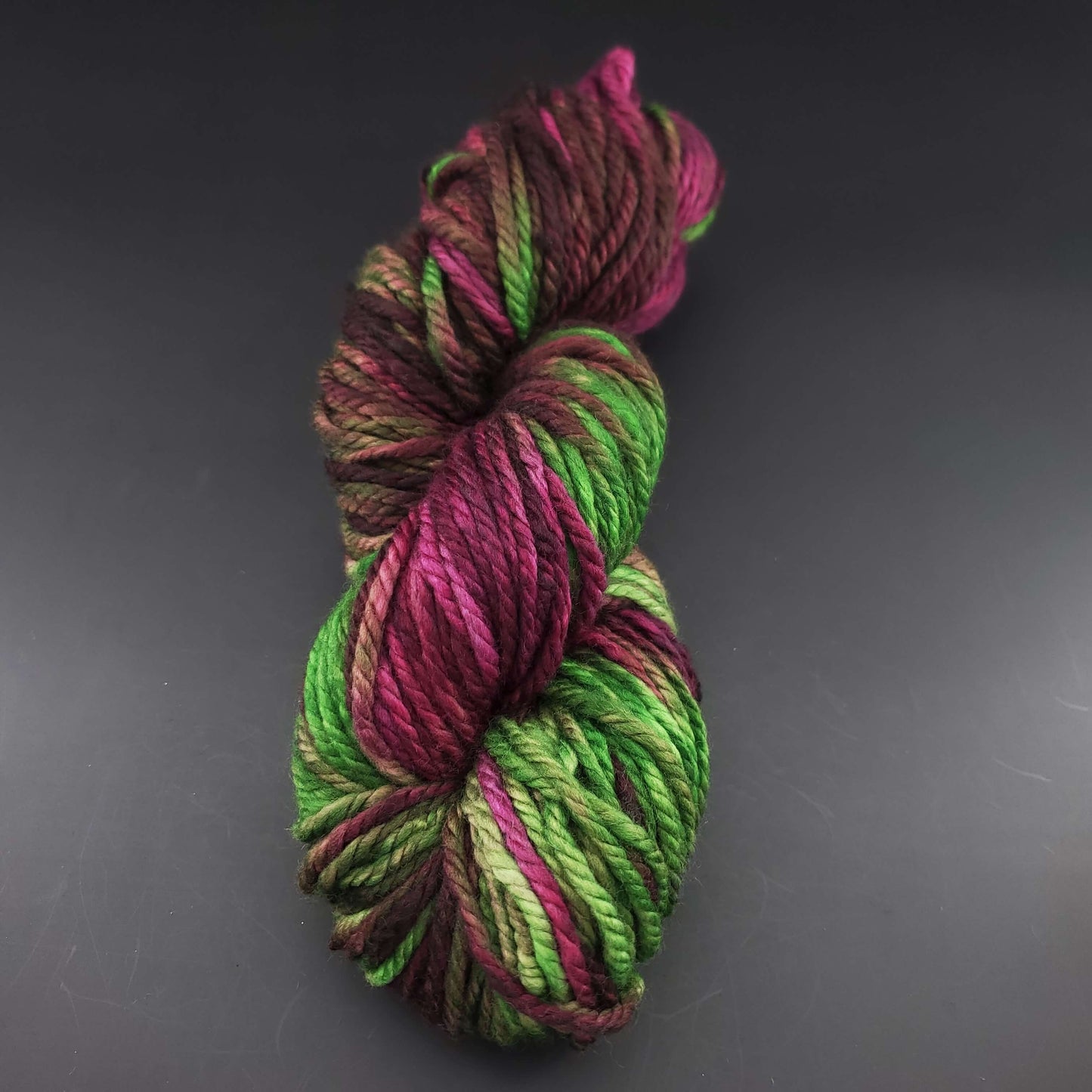 Echeveau de laine Malabrigo Chunky de couleur 239 sapphire magenta sur fond noir pour tricot et crochet.
