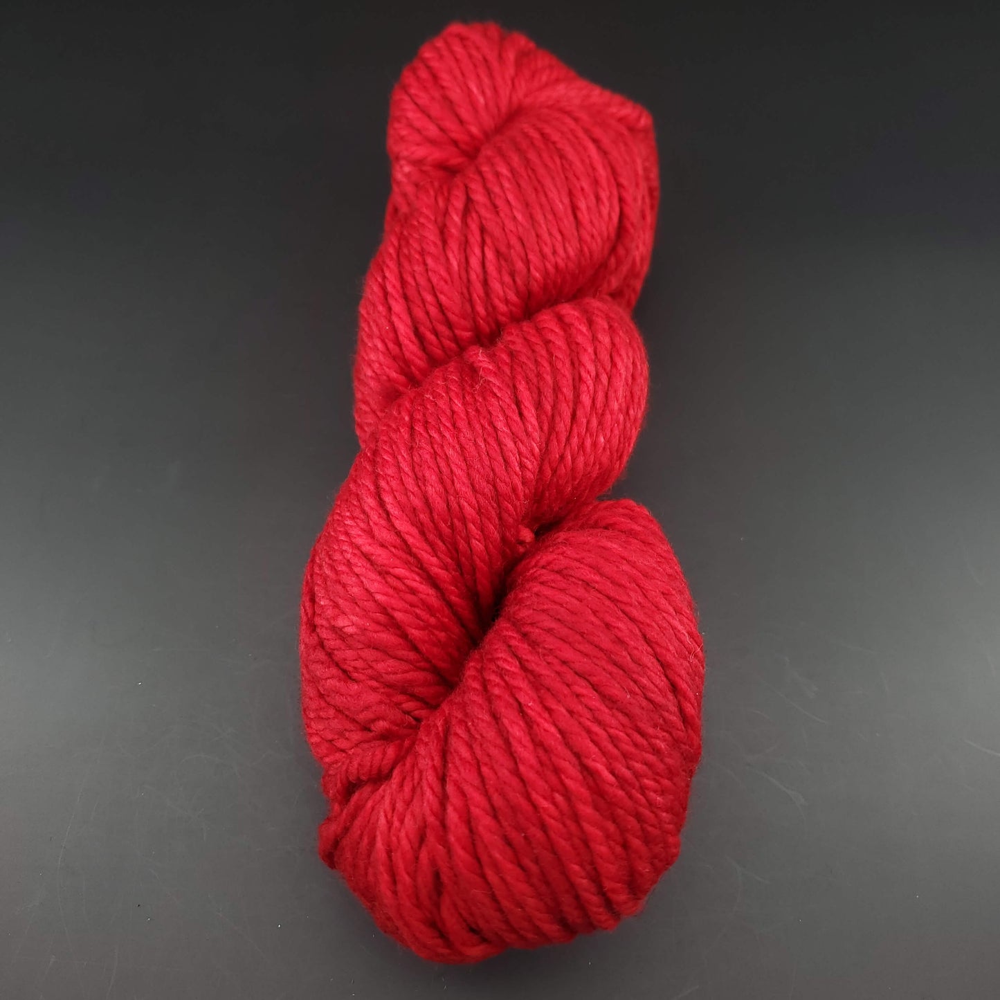 Echeveau de laine Malabrigo Chunky de couleur 611 ravelry red sur fond noir pour tricot et crochet.
