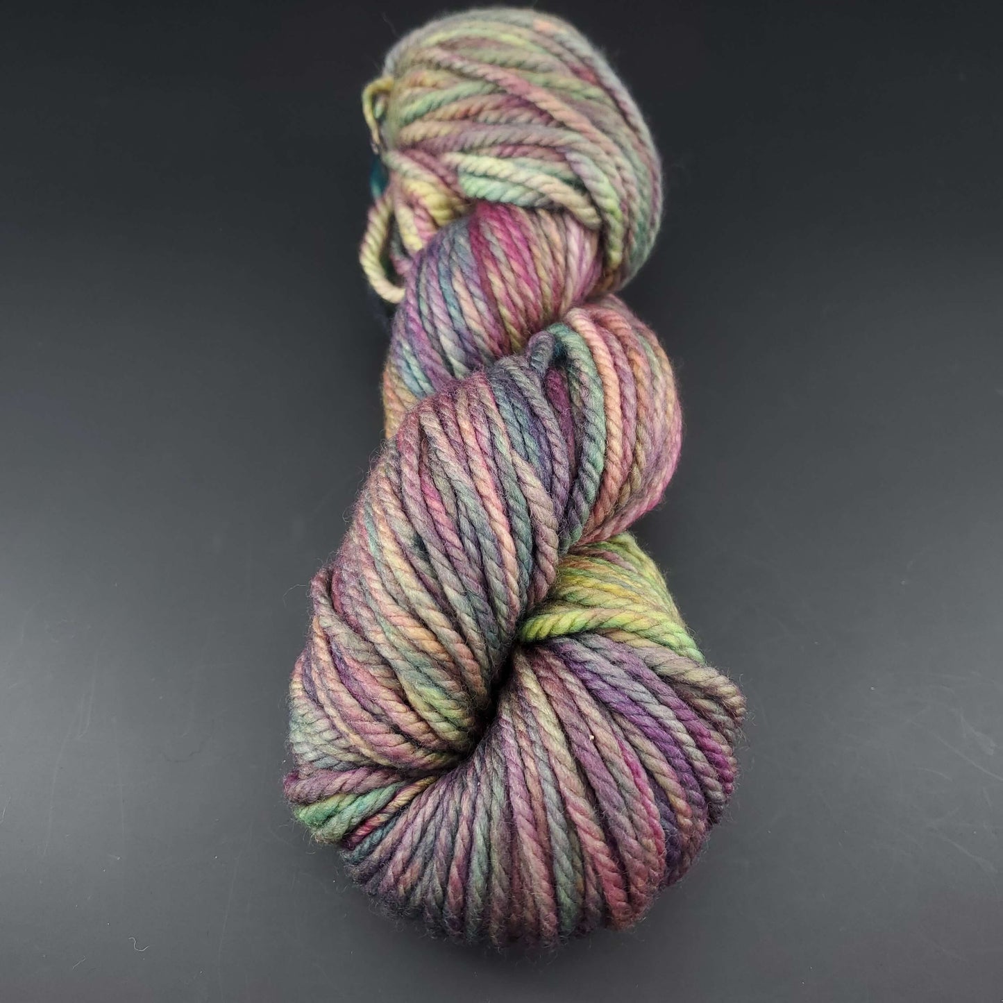 Echeveau de laine Malabrigo Chunky de couleur 866 arco iris sur fond noir pour tricot et crochet.