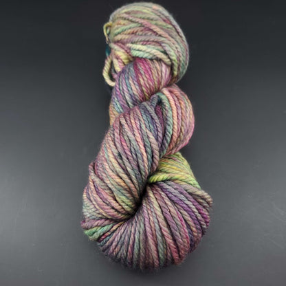 Echeveau de laine Malabrigo Chunky de couleur 866 arco iris sur fond noir pour tricot et crochet.