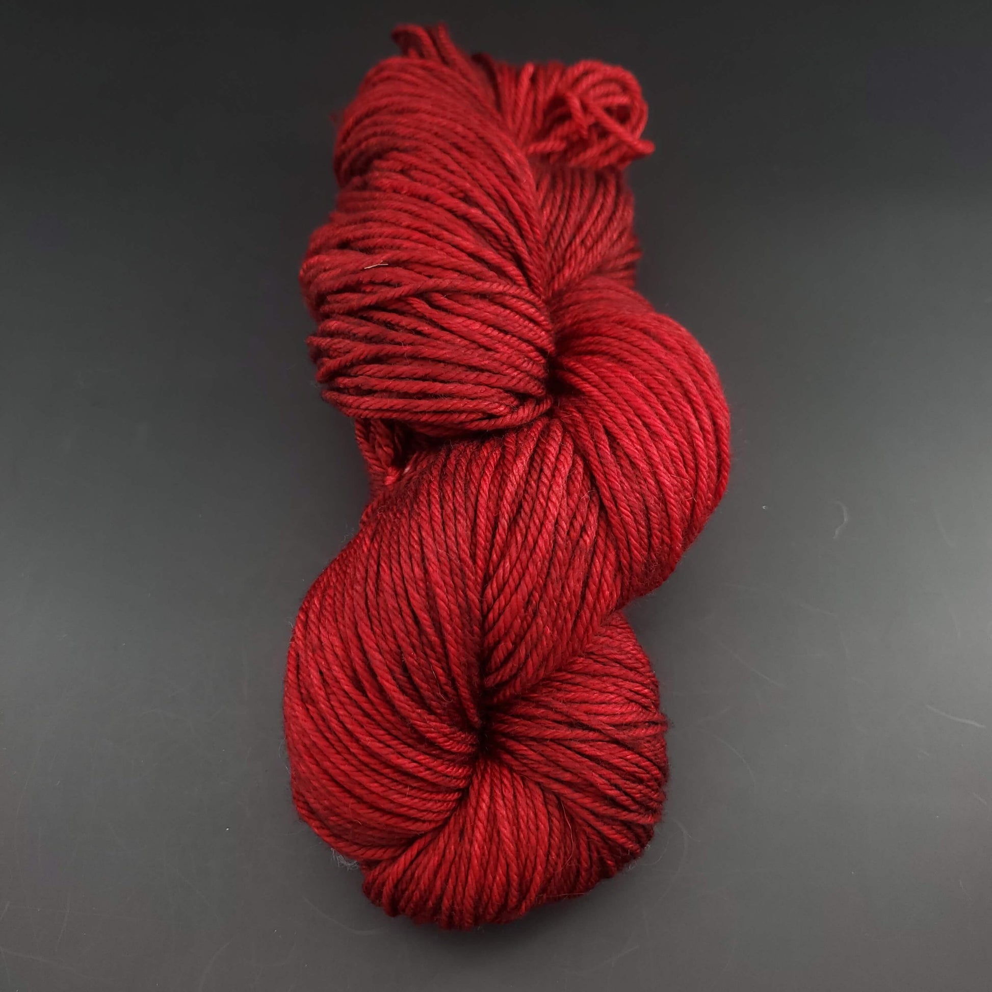 Echeveau de laine Malabrigo Rios de couleur 033 cereza sur fond noir pour tricot et crochet.