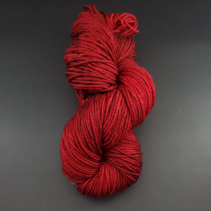 Echeveau de laine Malabrigo Rios de couleur 033 cereza sur fond noir pour tricot et crochet.
