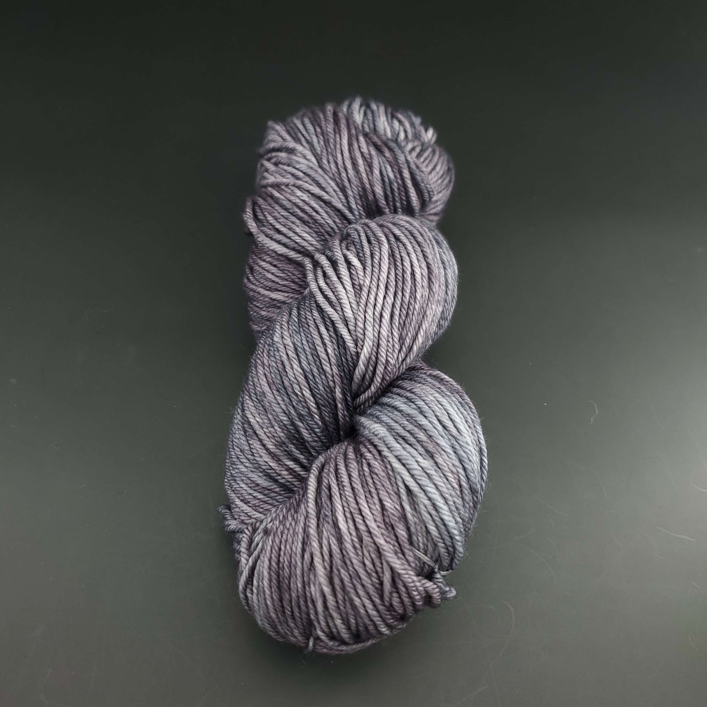 Echeveau de laine Malabrigo Rios de couleur 043 plomo sur fond noir pour tricot et crochet.