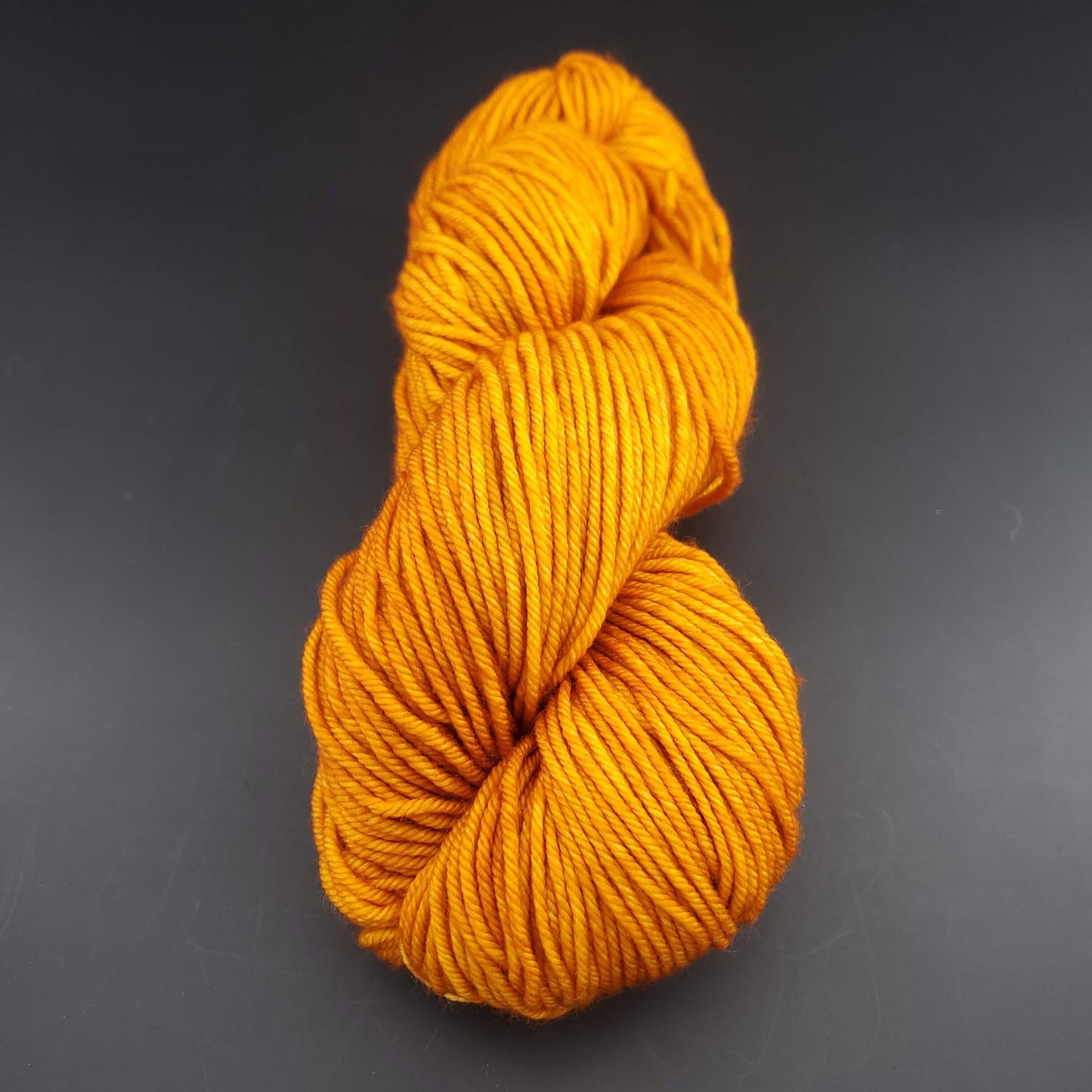 Echeveau de laine Malabrigo Rios de couleur 096 sunset sur fond noir pour tricot et crochet.