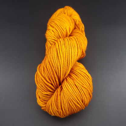 Echeveau de laine Malabrigo Rios de couleur 096 sunset sur fond noir pour tricot et crochet.