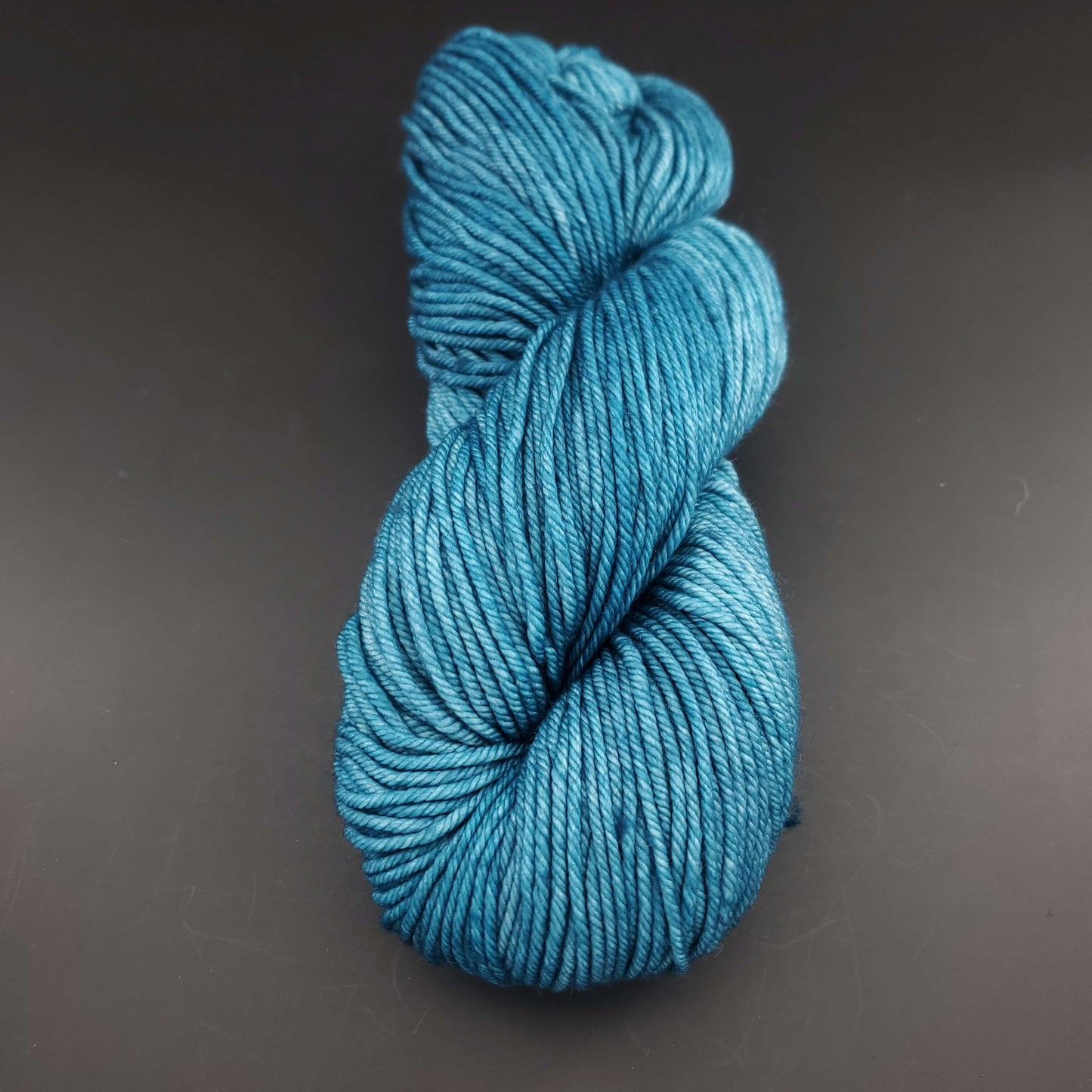 Echeveau de laine Malabrigo Rios de couleur 133 reflecting pool sur fond noir pour tricot et crochet.