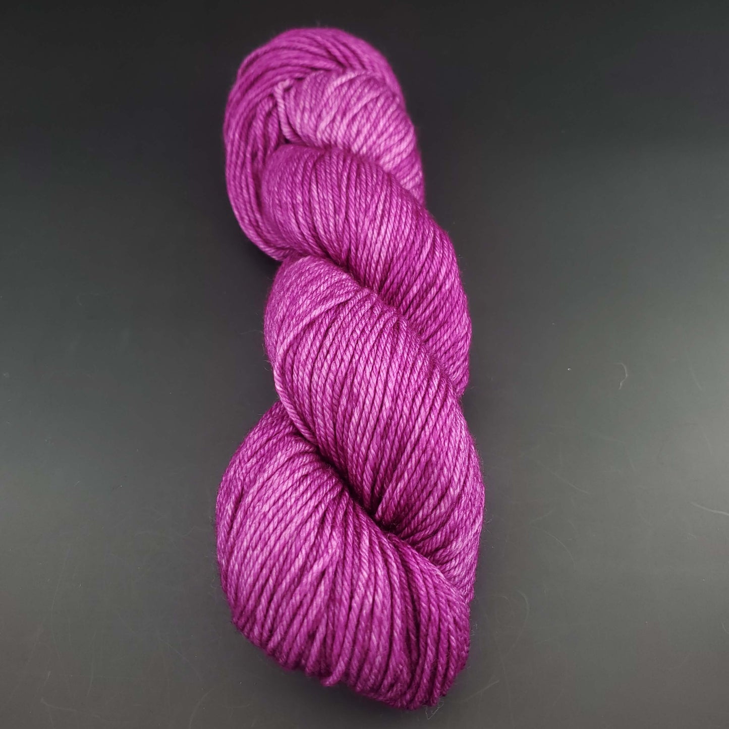 Echeveau de laine Malabrigo Rios de couleur 148 hollyhock sur fond noir pour tricot et crochet.