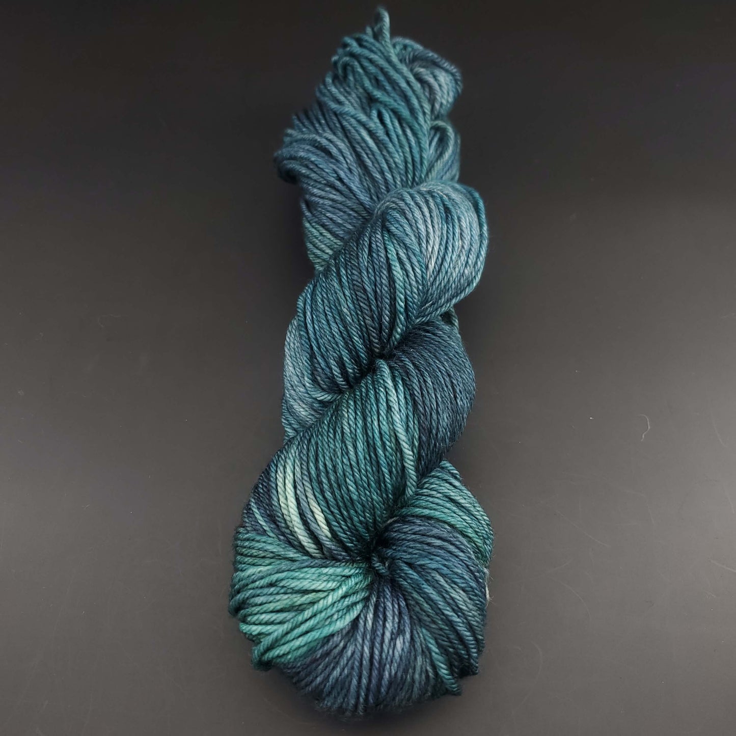 Echeveau de laine Malabrigo Rios de couleur 855 aguas sur fond noir pour tricot et crochet.