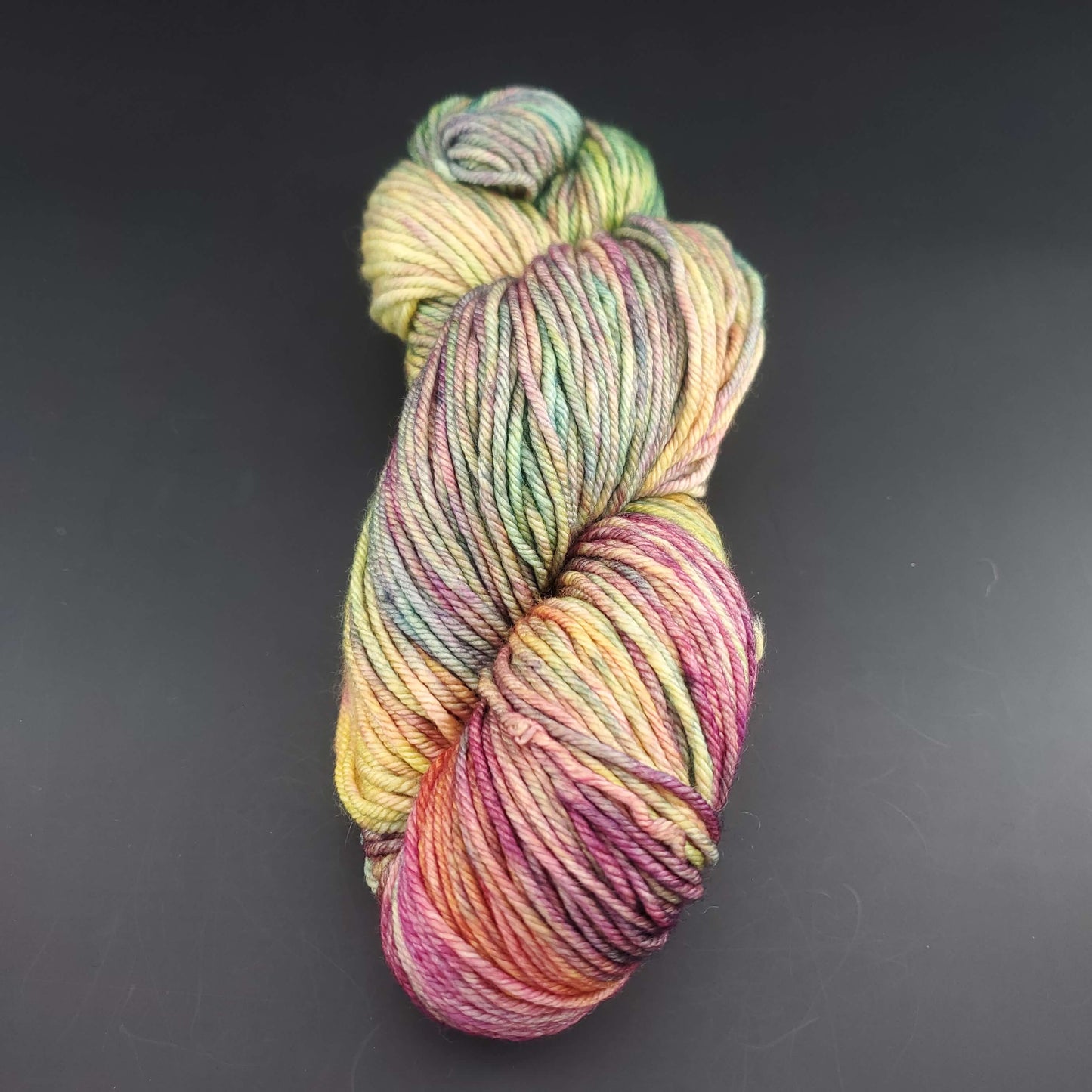 Echeveau de laine Malabrigo Rios de couleur 866 arco iris sur fond noir pour tricot et crochet.