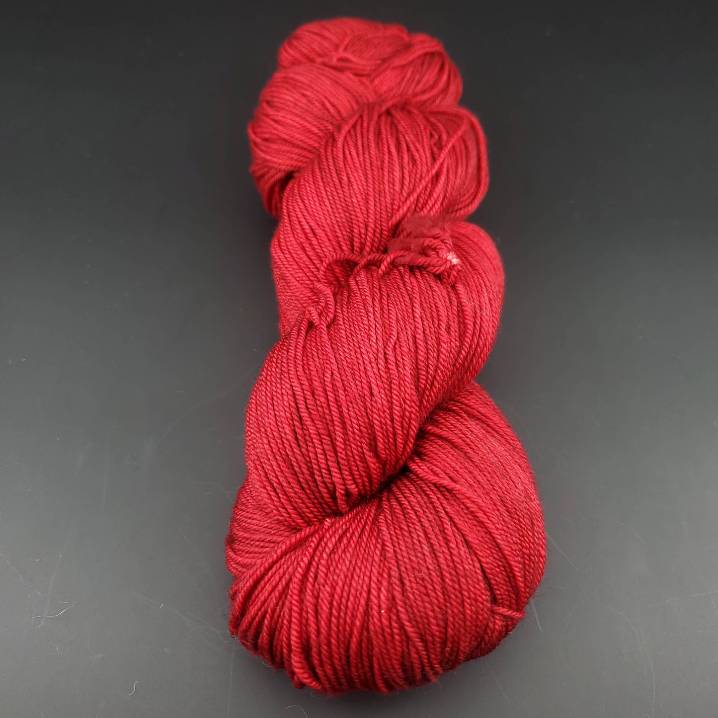 Echeveau de laine Malabrigo Sock de couleur 033 cereza sur fond noir pour tricot et crochet.