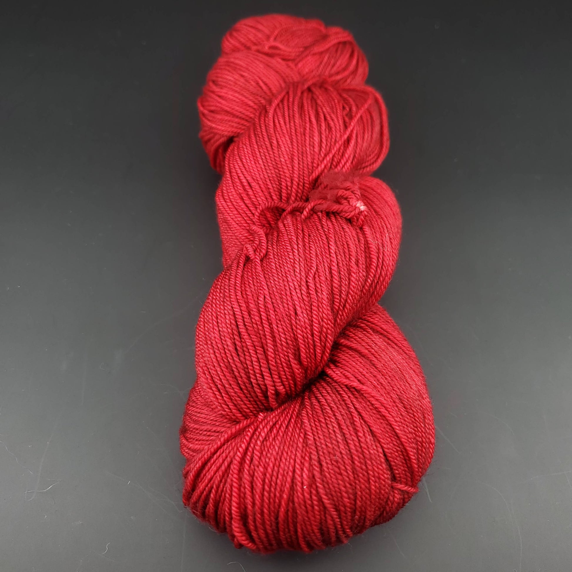 Echeveau de laine Malabrigo Sock de couleur 033 cereza sur fond noir pour tricot et crochet.