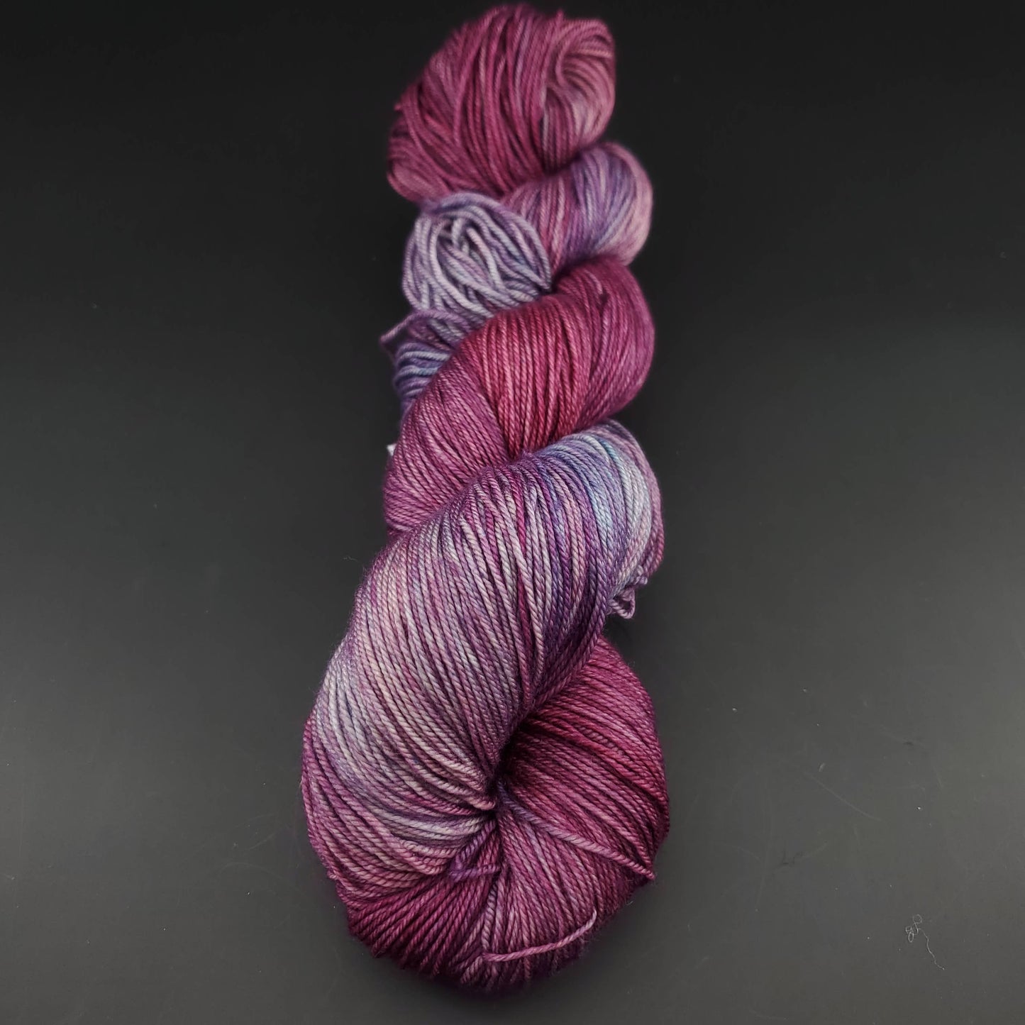 Echeveau de laine Malabrigo Sock de couleur 120 lotus sur fond noir pour tricot et crochet.