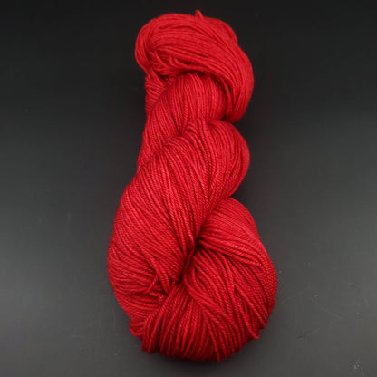Echeveau de laine Malabrigo Sock de couleur 611 ravelry red sur fond noir pour tricot et crochet.