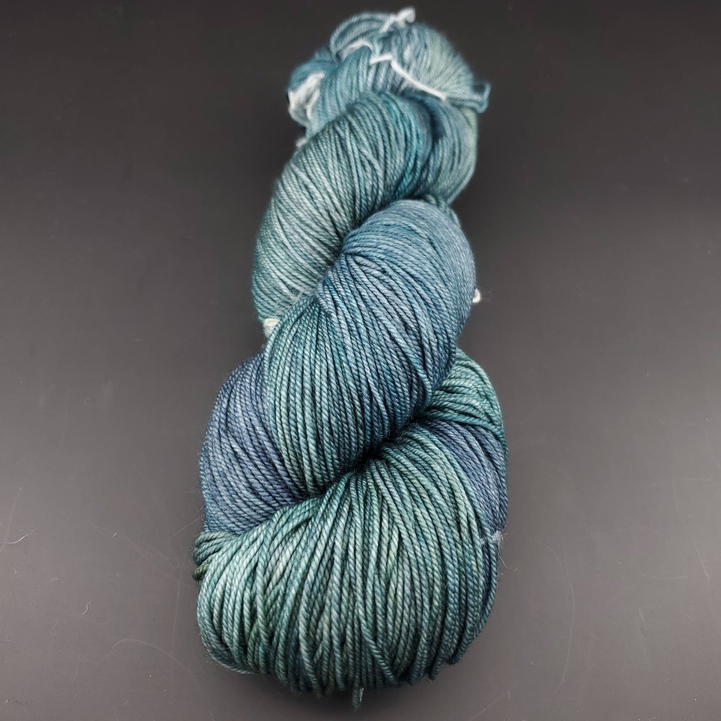 Echeveau de laine Malabrigo Sock de couleur 855 aguas sur fond noir pour tricot et crochet.