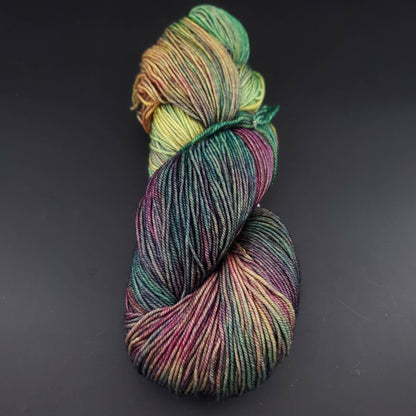 Echeveau de laine Malabrigo Sock de couleur 866 arco iris sur fond noir pour tricot et crochet.