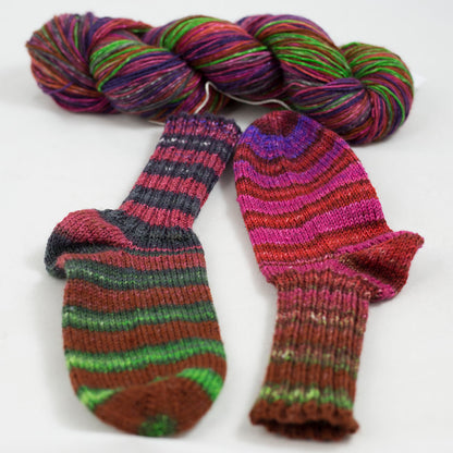 écheveau de laine à chaussettes Lazy Lion, multicolore, marque Kremke et paire de chaussettes tricotées (rose, rouge, violet, vert)