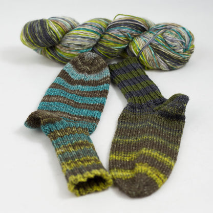 écheveau de laine à chaussettes Lazy Lion, multicolore, marque Kremke et paire de chaussettes tricotées (turquoise, jaune, marron)